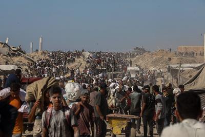 Palestinians suffering from extreme hunger under Israel intense attacks and blockade gather at an aid distribution center near the Zikim border crossing in Gaza to access limited food-stock-foto