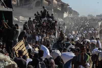 Palestinians suffering from extreme hunger under Israel intense attacks and blockade gather at an aid distribution center near the Zikim border crossing in Gaza to access limited food-stock-foto