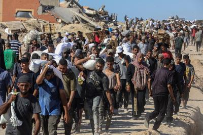 Palestinians suffering from extreme hunger under Israel intense attacks and blockade gather at an aid distribution center near the Zikim border crossing in Gaza to access limited food-stock-foto