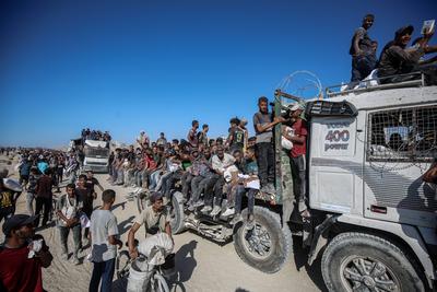 Palestinians suffering from extreme hunger under Israel intense attacks and blockade gather at an aid distribution center near the Zikim border crossing in Gaza to access limited food-stock-foto