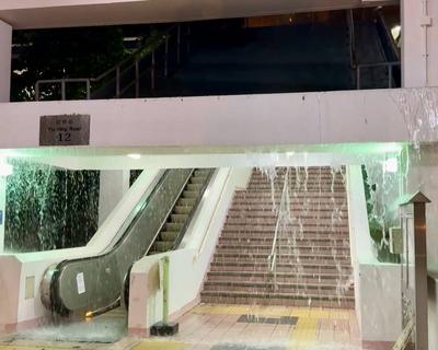 HONG KONG, CHINA - AUGUST 05: A waterfall cascades down from the entrance of an escalator in Yiu Tung Estate in Shau Kei-stock-foto