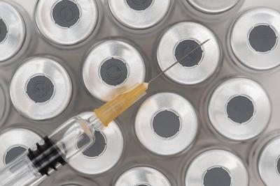 Impfung mit Ampullen und Spritze Eine Impfspritze liegt auf Ampullen mit Serum f?r eine Impfung *** Vaccination with amp-stock-foto