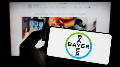 Person holding cellphone with logo of German pharmaceutical company Bayer AG on screen. Stuttgart, Germany - 04-16-2023:-stock-foto