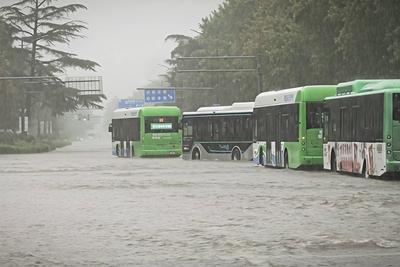 ZHENGZHOU, CHINA - AUGUST 07: Buses get stuck in the waterlogged road amid torrential rain on August 7, 2025 in Zhongyua-stock-foto