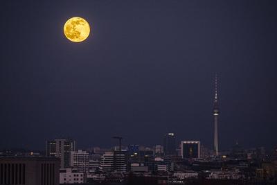 Der aufgehende Vollmond zeichnet sich ab hinter der Stadtansicht auf Berlin, 27.02.2021. Berlin Deutschland *** The ris-stock-foto