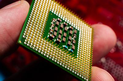 Ein Computertechniker installiert einen Prozessor. Ein Mikroprozessor, bei dem der Siliziumkern und der Cache-Chip deutlich sichtbar sind. Einbau eines Computerprozessors in einen Sockel-stock-foto