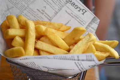 Pommes frites in einer Papiert?te, Stra?burg, Frankreich *** French fries in a paper bag, Strasbourg, France-stock-foto
