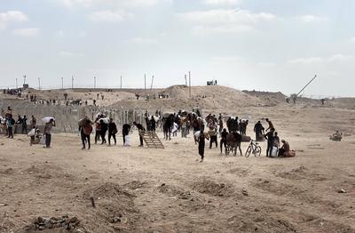Displaced Palestinians struggling with hunger flock to an aid distribution point set up in the Netzarim Corridor in hopes of receiving limited humanitarian aid in Deir al Balah-stock-foto