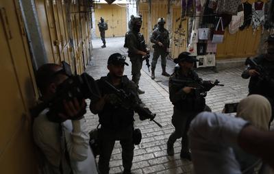 Israeli security forces stand guard as Israeli settlers tour in the Palestinian side of the old city and market of Hebron-stock-foto