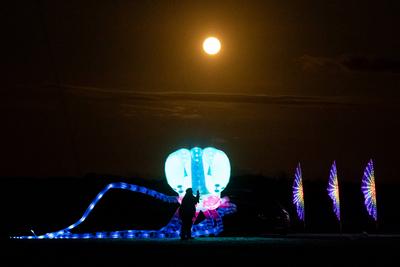 Beleuchtete Drachen vor Vollmond in Sankt Peter-Ording-stock-foto