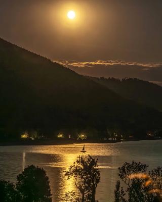 Der Vollmond leuchtet ?ber dem Tegernsee, das Wasser glitzert im Mondschein, ein Segelboot kreuzt auf dem Wasser, romantische Mondnacht, Gmund, Nacht vom 8. auf den 9. August 2025-stock-foto