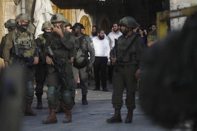 Israeli security forces stand guard as Israeli settlers tour in the Palestinian side of the old city and market of Hebron-stock-foto