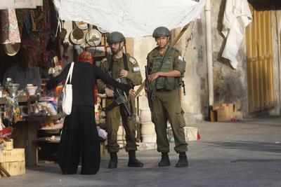 Israeli security forces stand guard as Israeli settlers tour in the Palestinian side of the old city and market of Hebron-stock-foto