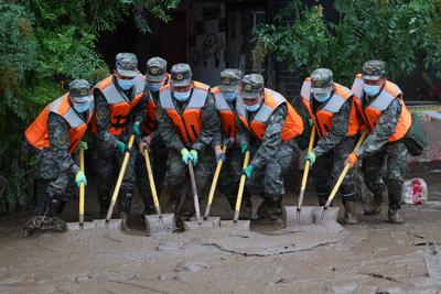 YUZHONG, CHINA - AUGUST 10: Rescuers clean up mud after continuous heavy rainfall triggered mountain torrents on August-stock-foto