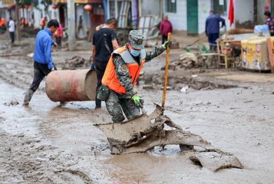 YUZHONG, CHINA - AUGUST 10: Rescuers clean up mud after continuous heavy rainfall triggered mountain torrents on August-stock-foto