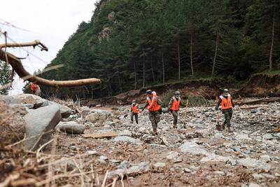 YUZHONG, CHINA - AUGUST 10: Rescuers search for villager s missing materials after continuous heavy rainfall triggered m-stock-foto