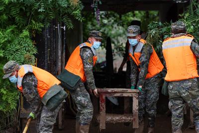 YUZHONG, CHINA - AUGUST 10: Rescuers move materials after continuous heavy rainfall triggered mountain torrents on Augus-stock-foto