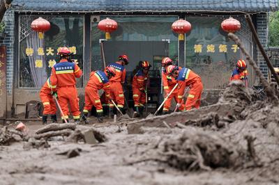 YUZHONG, CHINA - AUGUST 10: Rescuers clean up mud after continuous heavy rainfall triggered mountain torrents on August-stock-foto