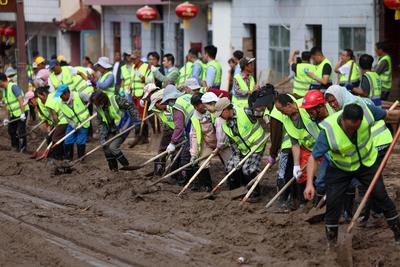 YUZHONG, CHINA - AUGUST 10: Rescuers clean up mud after continuous heavy rainfall triggered mountain torrents on August-stock-foto