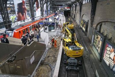 cntv Mit einen Bagger auf Schienen der auf den Bahngleisen faehrt und Mitarbeitern sind die Bauarbeiten f?r die Erneuerung der Bahnsteige 3 und 4 am Hauptbahnhof in vollen gange11.08.2025 Hamburg - Hauptbahnhof Die Bauerabeiten werden bis mitte September andauern Die Bauarbeiten zur Erneuerung der Bahnsteige 3 und 4 am Hamburger Hauptbahnhof haben heute begonnen. Die Arbeiten sollen ca. bis November andauern. F?r die Zeit der Arbeiten ist jeweils immer ein Gleis der Gleise 3 oder 4 voll gesperrt. Hamburg Deutschland *** cntv With an excavator on rails driving on the tracks and employees, the construction work for the renewal of platforms 3 and 4 at Hamburg Central Station is in full swing11 08 2025 Hamburg Central Station The constructi-stock-foto