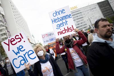 1. Mai Demo DEU, Deutschland, Germany, Berlin, 01.05.2022 Demonstrant mit Plakat Ohne Hebamme geht nichts Yes we Care ge-stock-foto