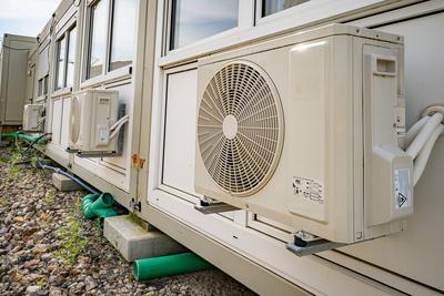 W?rmepumpe - bzw. Klima-Splitger?te sorgen f?r angenehme Raumtemperaturen im B?rocontainer auf einer Baustelle.-stock-foto