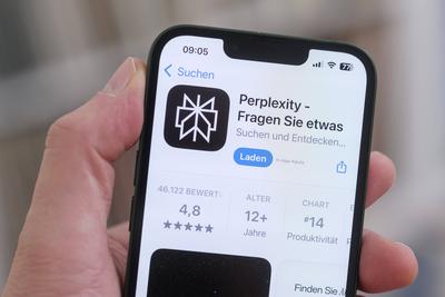 Ein Mobiltelefon mit ge?ffneter Apple App Store Seite zeigt die Perplexity App zum Download. Symbolbild f?r k?nstliche Intelligenz und den wachsenden Einfluss von KI-Anwendungen im Alltag. *** A cell phone with the Apple App Store page open shows the Perplexity app for download. Symbolic image for artificial intelligence and the growing influence of AI applications in everyday life.-stock-foto