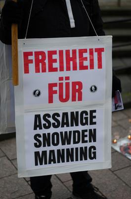 Mahnwache an der Holmnixe - Freiheit f?r Julian Assange Protestschild h?ngt am K?rper einer Demonstrantin, auf diesem st-stock-foto