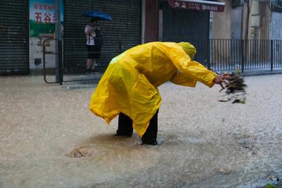 HONG KONG, CHINA - AUGUST 14: A worker removes debris that blocks drain outlet amid heavy rain on August 14, 2025 in Hon-stock-foto