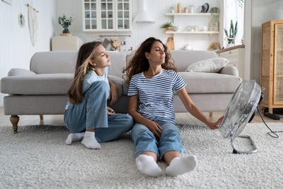 Liebevolle sorglose Frau Mutter und Teenager-M?dchen sitzt in entspannter Position auf dem Boden im Wohnzimmer in der N?he von Fan-stock-foto