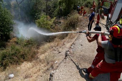 Firefighters spray water on a fire in the town of Delvine, south-east Albania, on August 13, 2025, as fire crews, aided-stock-foto