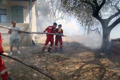Firefighters spray water on a fire in the town of Delvine, south-east Albania, on August 13, 2025, as fire crews, aided-stock-foto