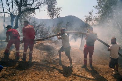 Firefighters spray water on a fire in the town of Delvine, south-east Albania, on August 13, 2025, as fire crews, aided-stock-foto