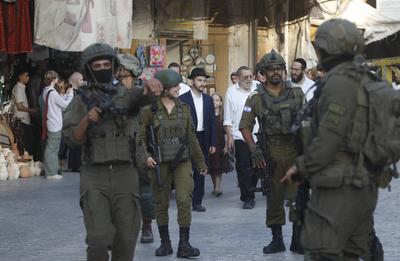 Israeli security forces stand guard as Israeli settlers tour in the Palestinian side of the old city and market of Hebron-stock-foto