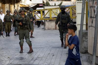 Israeli security forces stand guard as Israeli settlers tour in the Palestinian side of the old city and market of Hebron-stock-foto