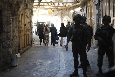Israeli security forces stand guard as Israeli settlers tour in the Palestinian side of the old city and market of Hebron-stock-foto