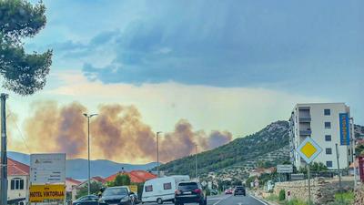 Unwetter l?st gr??eren Waldbrand in Kroatien aus: Schweres Gewitter zieht ?ber beliebte Urlaubsregion an der Adriak?ste - Blitzeinschlag setzt Wald auf Berg in Flammen - schwarze Rauchwolke steigt auf-stock-foto