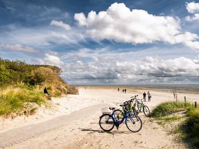 Fu?weg, der am Strand in Osterhook auf der ostfriesischen Insel Langeoog endet, Niedersachsen, Deutschland, Menschen genie?en die Wattenmeerlandschaft-stock-foto