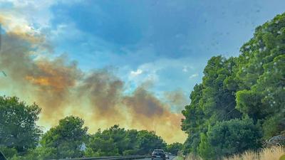 Unwetter l?st gr??eren Waldbrand in Kroatien aus: Schweres Gewitter zieht ?ber beliebte Urlaubsregion an der Adriak?ste - Blitzeinschlag setzt Wald auf Berg in Flammen - schwarze Rauchwolke steigt auf-stock-foto