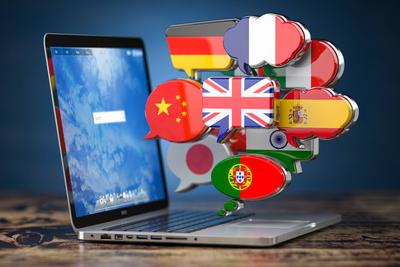 Globale Kommunikation, W?rterbuch, ?bersetzen und Sprachen lernen online app Konzept. Laptop und Sprechblasen mit Flaggen.-stock-foto
