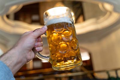 Berlin, Germany - 25 March 2025: A large, shiny beer mug with golden contents, held firmly in the hand - captured in the-stock-foto