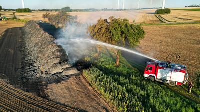Tagfotos: Gro?weitzschen - Dunkle Rauchwolken ?ber der A14: Mehr als 700 Strohballen in Flammen! Feuerwehr l?sst kontrolliert abbrennen-stock-foto