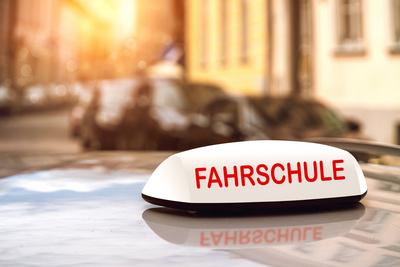 11 August 2024: Driving school sign on a car driving in a big city at sunset. Driving license and driving lessons symbol-stock-foto