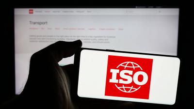Person holding mobile phone with logo of International Organization for Standardization (ISO).-stock-foto