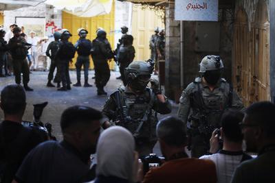 Israeli security forces stand guard as Israeli settlers tour in the Palestinian side of the old city and market of Hebron in the occupied-stock-foto