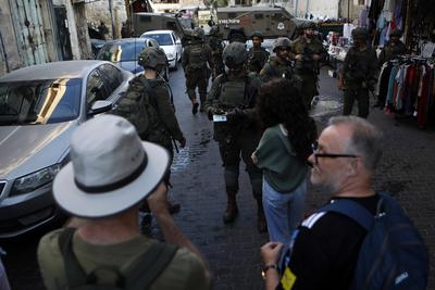 Israeli security forces stand guard as Israeli settlers tour in the Palestinian side of the old city and market of Hebron in the occupied-stock-foto