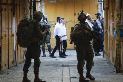 Israeli security forces stand guard as Israeli settlers tour in the Palestinian side of the old city and market of Hebron in the occupied-stock-foto