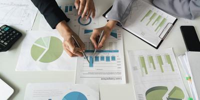 Zusammenarbeit bei Berichten. Kollegen, die in einer Sitzung Datenergebnisse diskutieren und vergleichen.-stock-foto