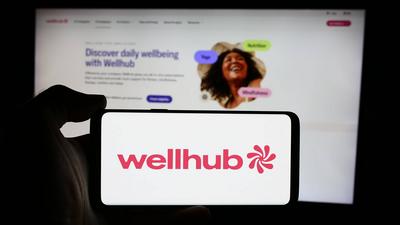 Person holding cellphone with logo of corporate wellness company Wellhub (Gympass US LLC).-stock-foto