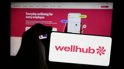Person holding mobile phone with logo of corporate wellness company Wellhub (Gympass US LLC).-stock-foto